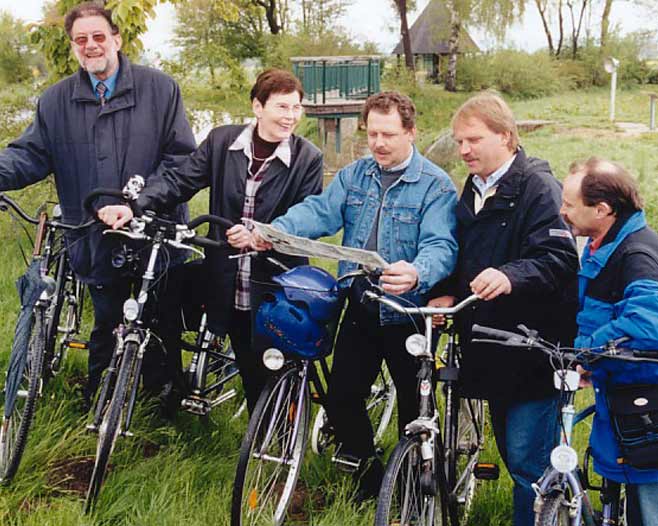 Vier Personen auf dem Fahrrad, die auf eine Landkarte gucken